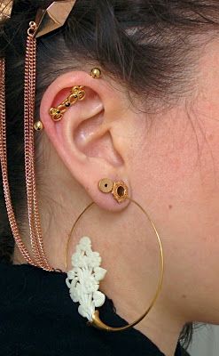 a close up of a person with ear rings and jewelry on their ears, wearing earrings