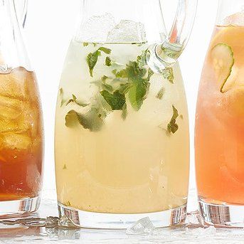 three pitchers filled with different types of drinks