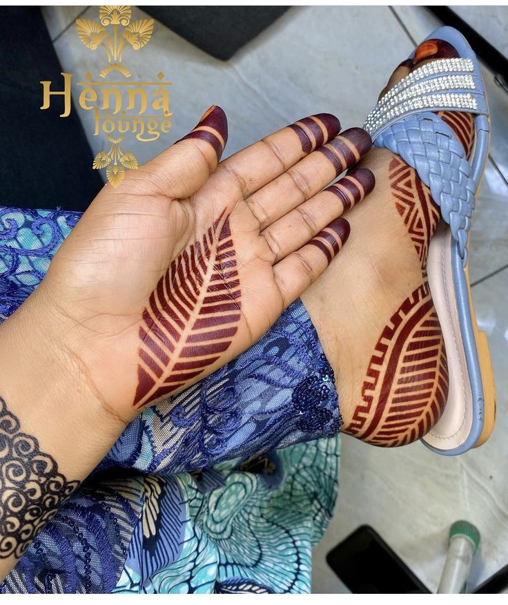 a woman's feet with henna tattoos on her hand and footnails