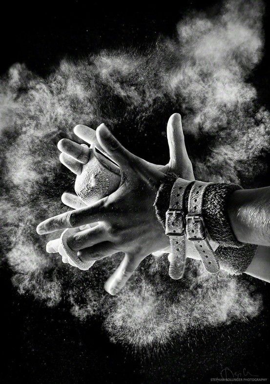 black and white photograph of two hands in the air with powder coming out of them