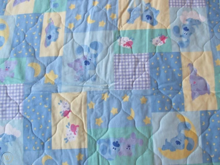 a blue and yellow baby quilt with elephants on it's side, in the shape of squares