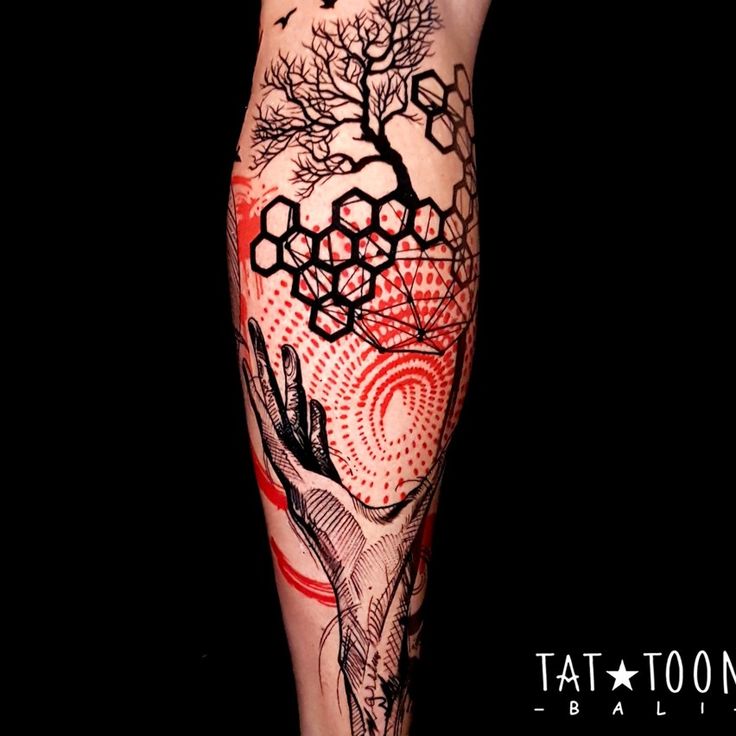 a person with tattoos on their legs and leg is covered in red, black and white ink