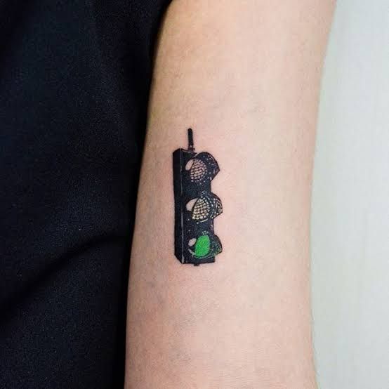 a small traffic light tattoo on the arm