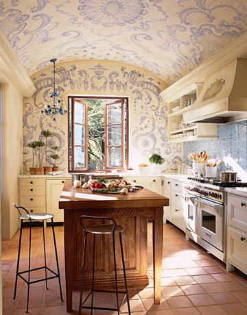 a large kitchen with an island in the center and two stools at the counter