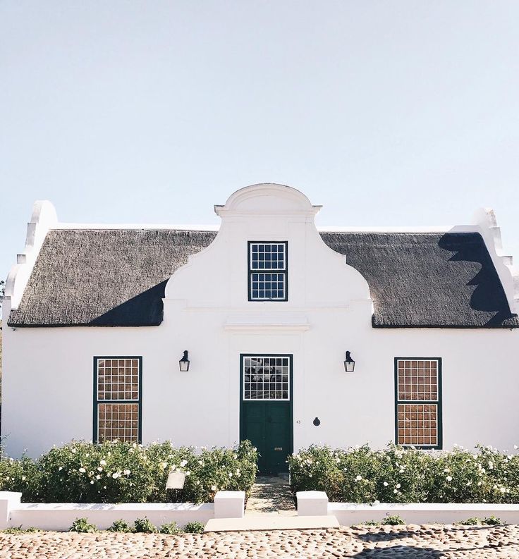 a white house with green doors and windows