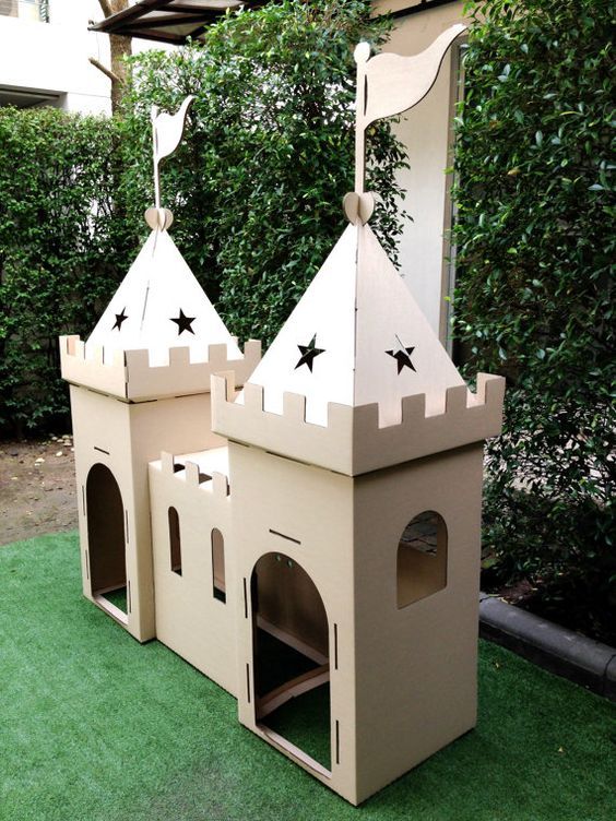 a dog house made out of cardboard with two towers and stars on the top one