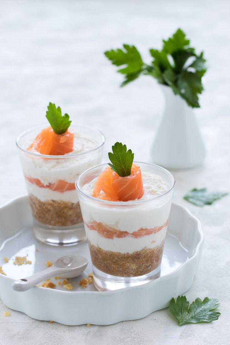 two desserts on a plate with spoons and parsley