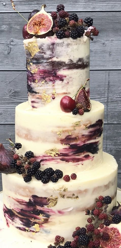 a three tiered cake with fruit on top