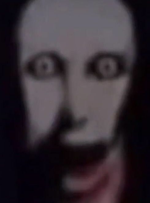 the face of a man with long hair and eyes is shown in this blurry image