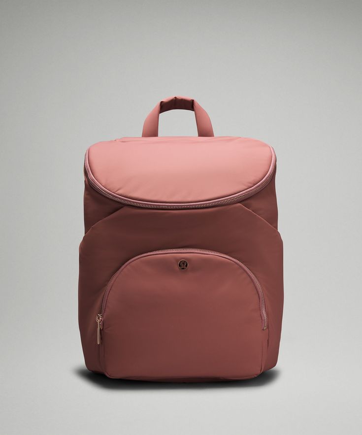 a pink backpack sitting on top of a gray surface