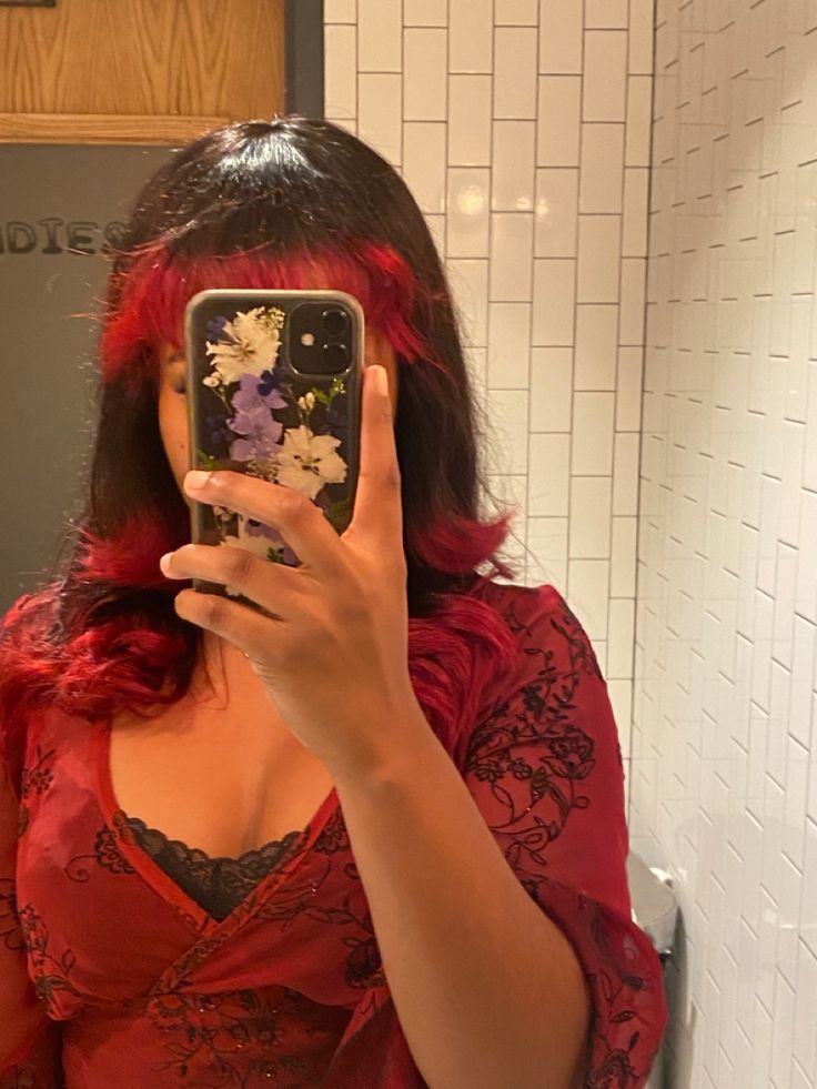 a woman with red hair is taking a selfie in the mirror while wearing a red dress