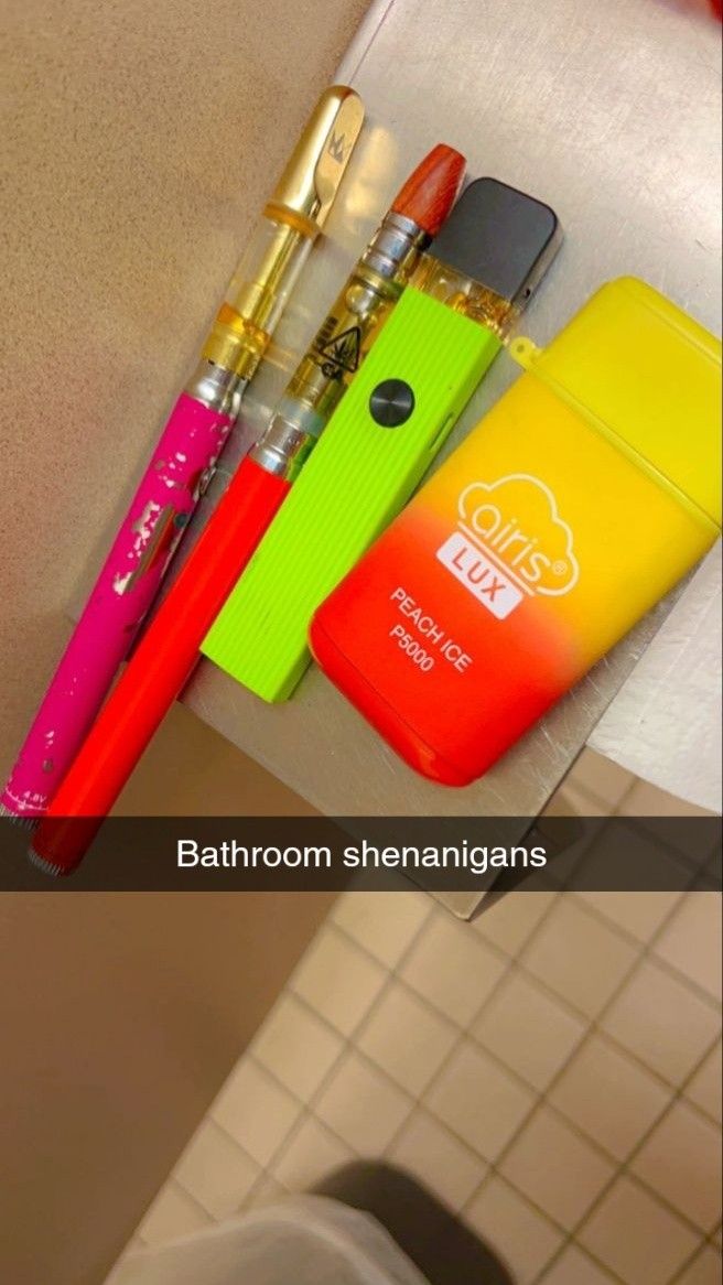 three pens and two lighters are sitting on the counter next to each other in a bathroom