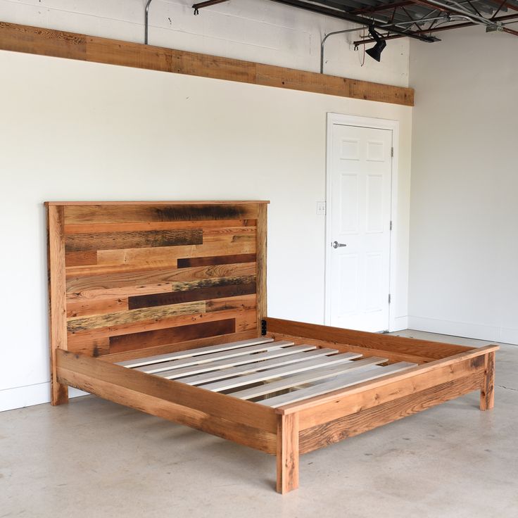 a bed made out of pallet wood in a room with white walls and flooring