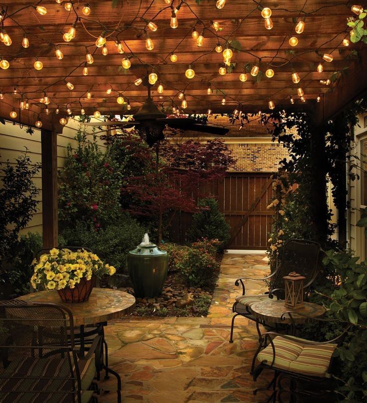 an outdoor patio with lights strung from the ceiling