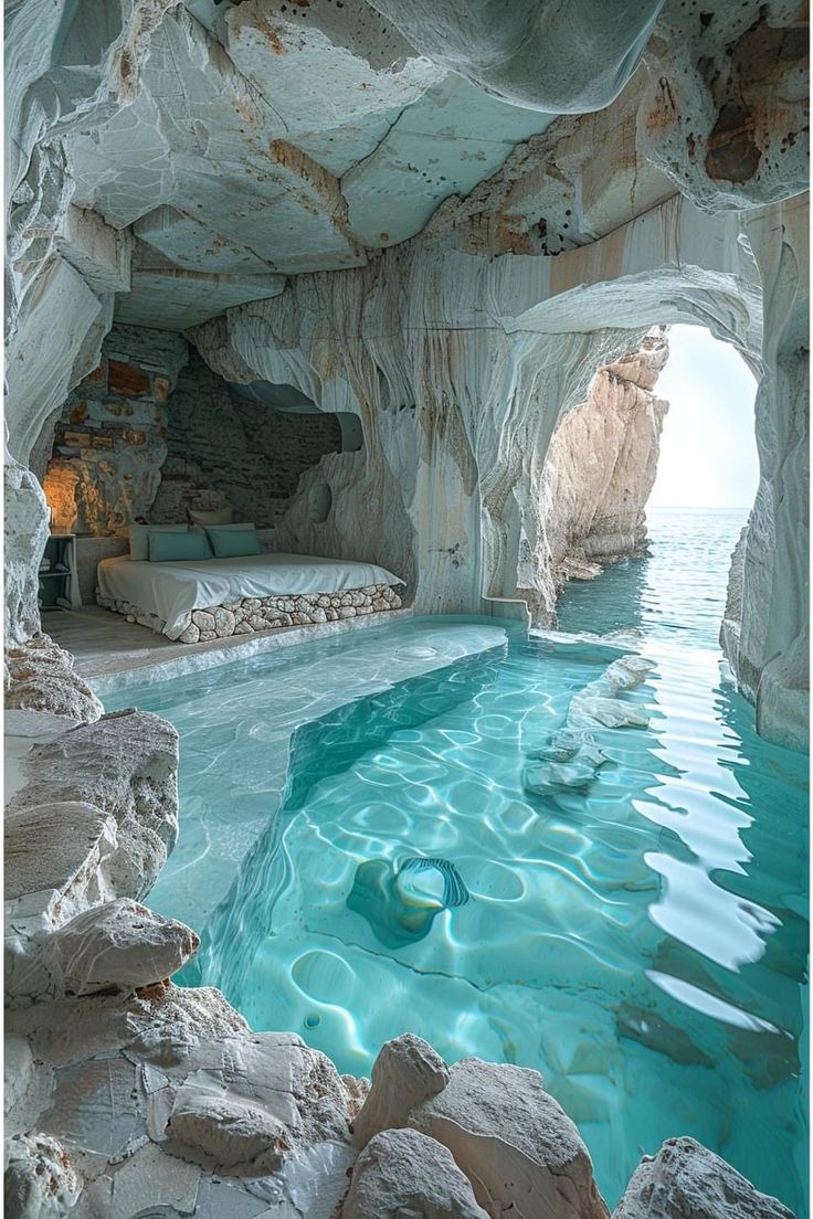 an indoor swimming pool in the middle of a cave with blue water and rocks surrounding it