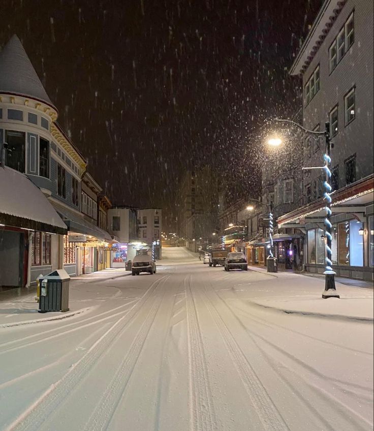 a city street is covered in snow at night