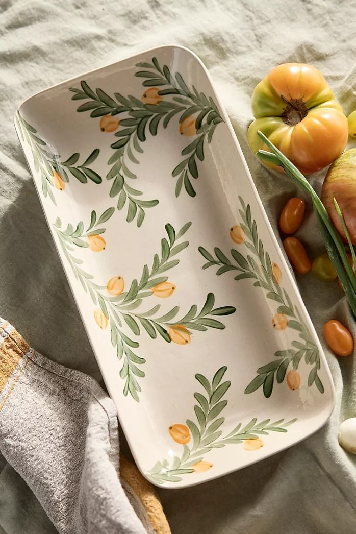 an assortment of fruits and vegetables sitting on a bed next to a cloth covered blanket