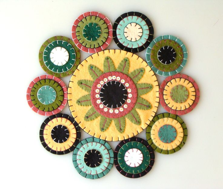 a multicolored circular wall hanging made out of ceramic tiles with circles around it