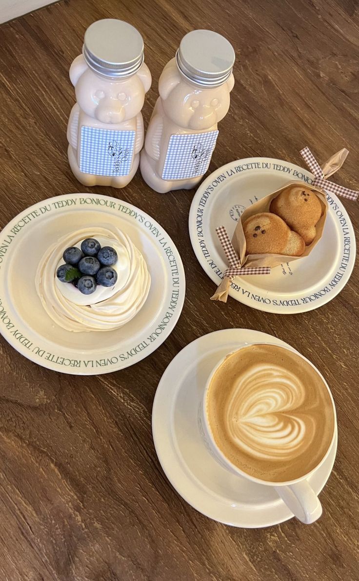 there are three plates with blueberries on them and two jars of milk in the background