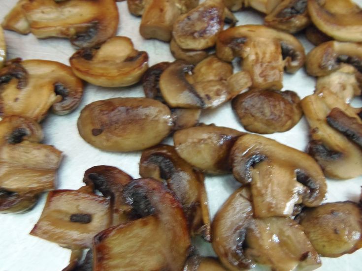 sliced mushrooms sitting on top of a white countertop covered in brown sauce and seasoning