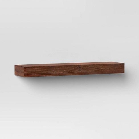 a wooden shelf is shown against a white wall