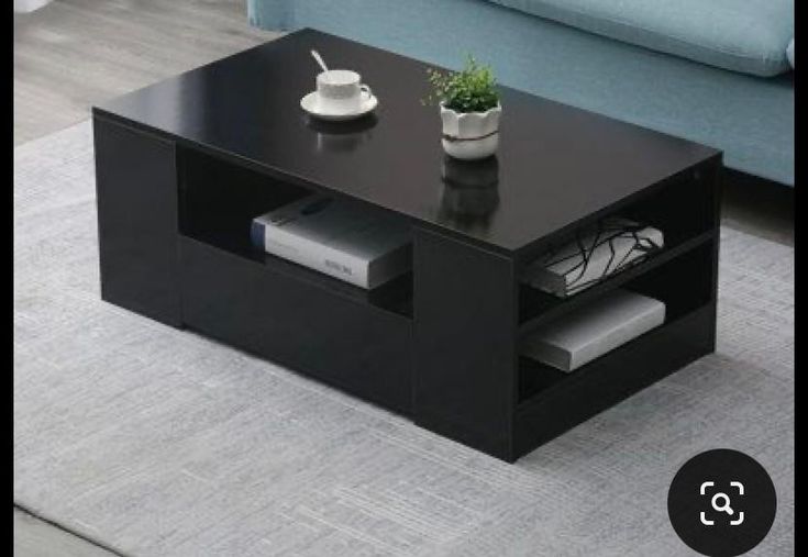 a black coffee table sitting on top of a rug