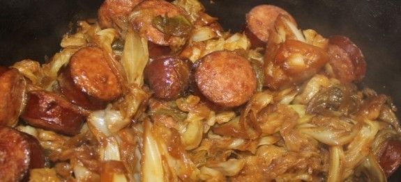 sausage and onions cooking in a pan on the stove