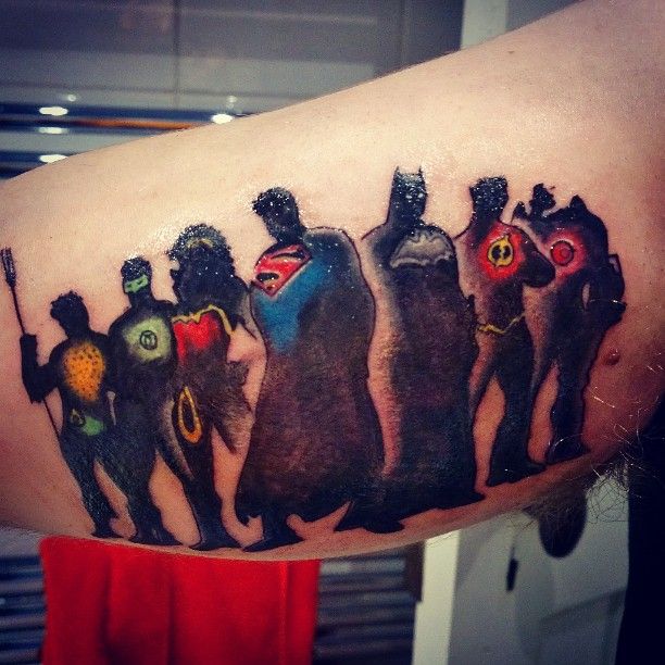 a man's arm with an image of five superheros painted on the side