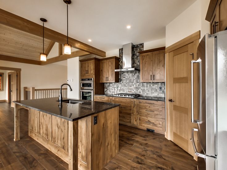 a large kitchen with wooden cabinets and an island in the middle, along with stainless steel appliances