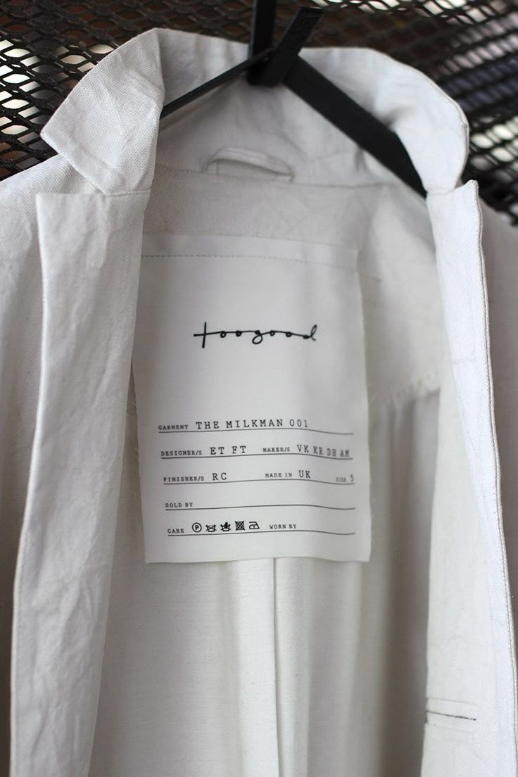 a white shirt hanging on a hanger with a tag that says, tropel