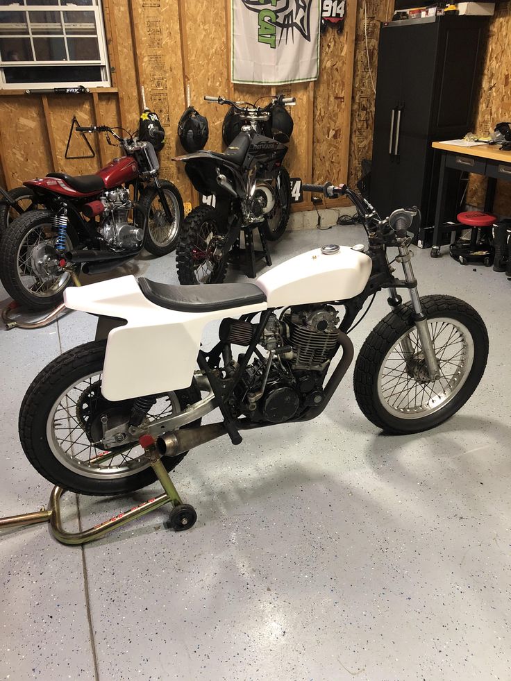 a motorcycle parked in a garage next to other motorcycles