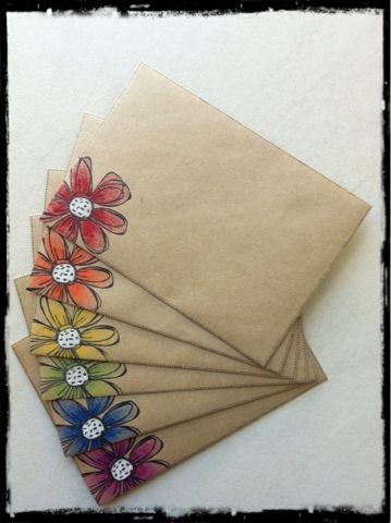 four envelopes with flowers on them sitting next to each other