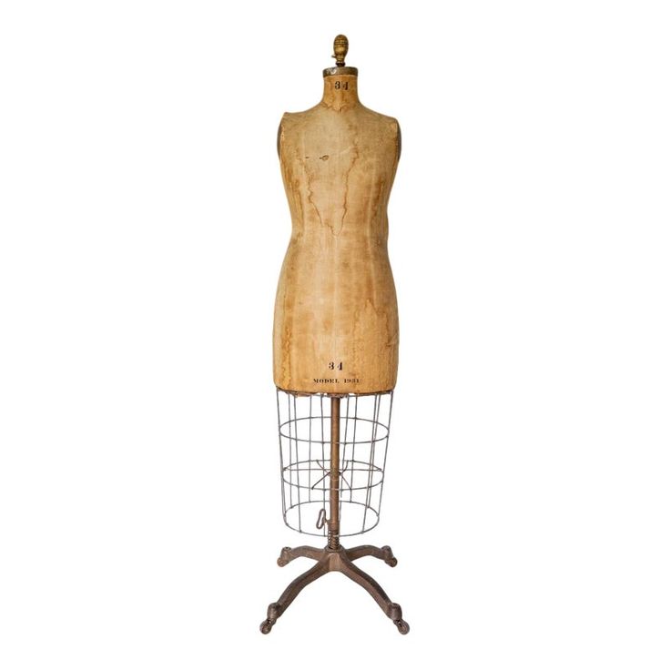 an old wooden mannequin is standing on a metal stand with a white background