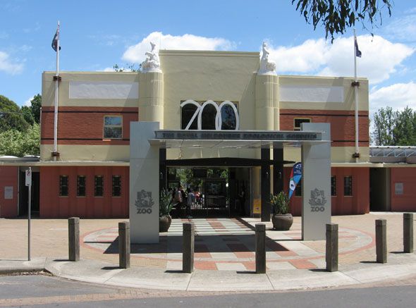 the front entrance to a building with flags flying in the wind