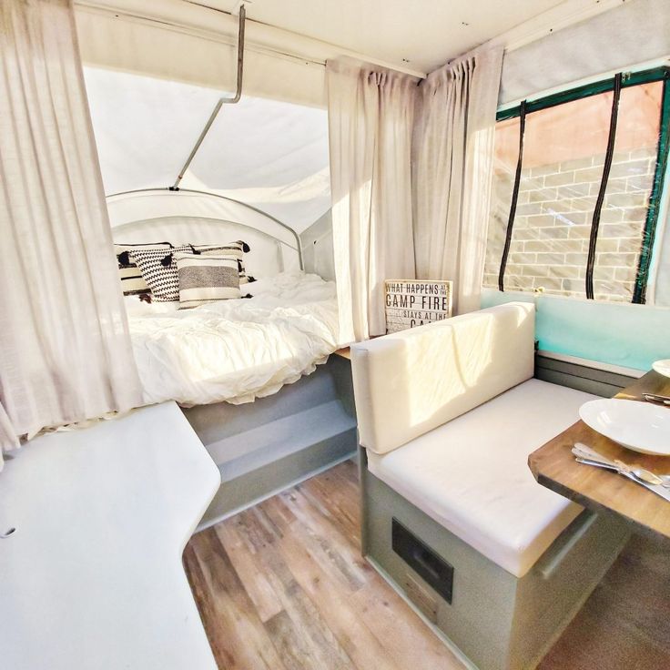 the interior of a camper with a bed and table