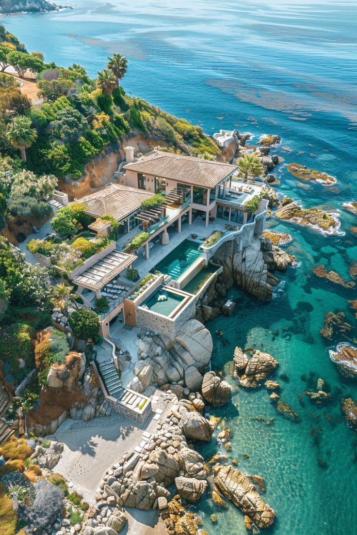 an aerial view of a house on the ocean