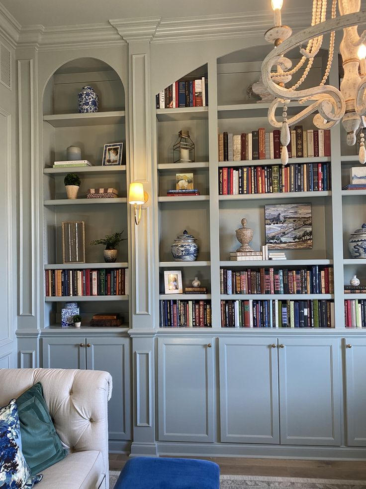 a living room filled with lots of bookshelves covered in white bookcases