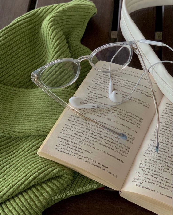 an open book with glasses on top of it