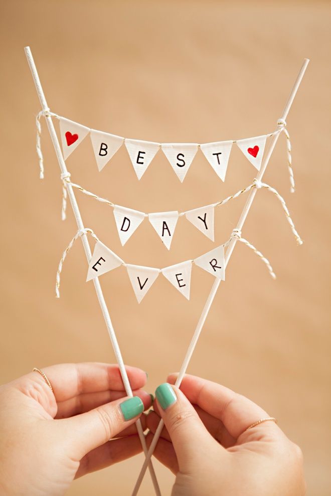 a person holding up a cake topper with the words best day ever on it