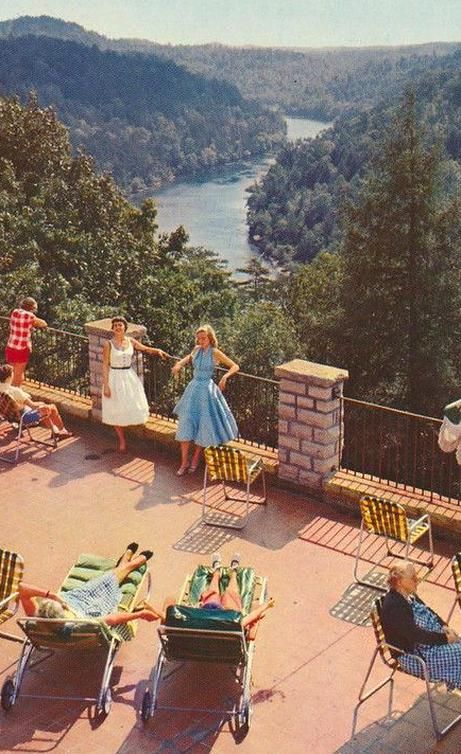 a group of people standing on top of a roof next to lawn chairs