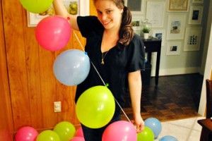 a woman is holding balloons in her hand