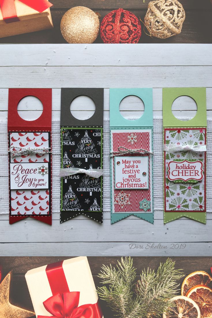 four christmas door hangers decorated with holiday sayings and ornaments on top of a wooden table