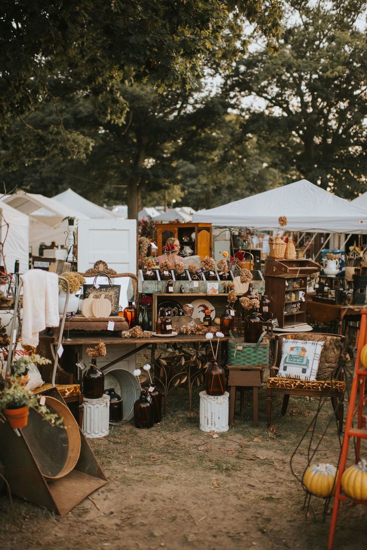 an outdoor flea market with tables and chairs