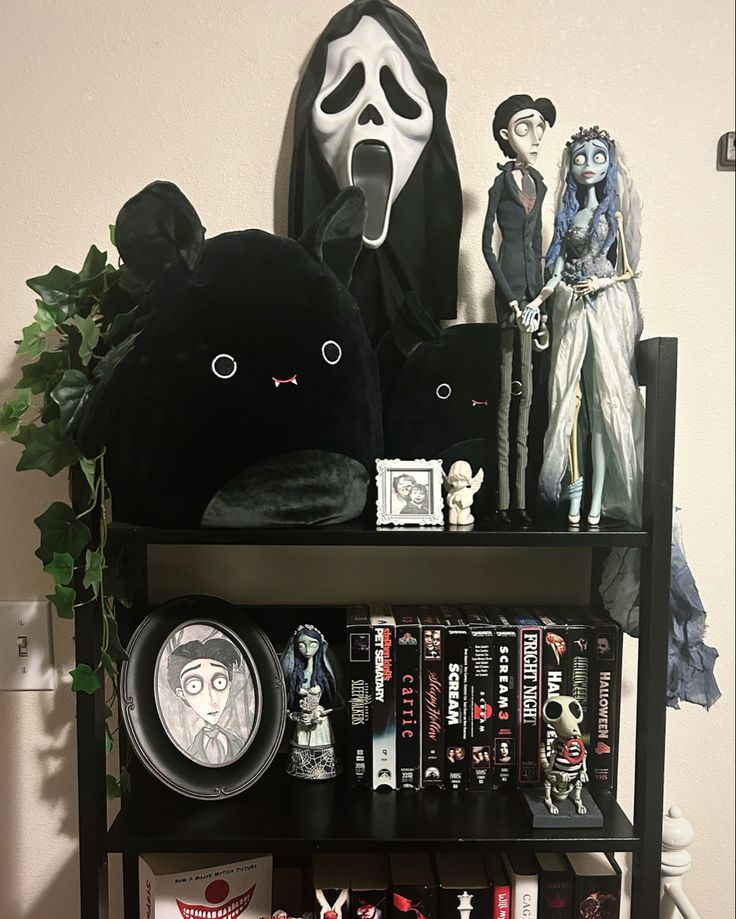 a book shelf filled with books and figurines next to a wall mounted ghost