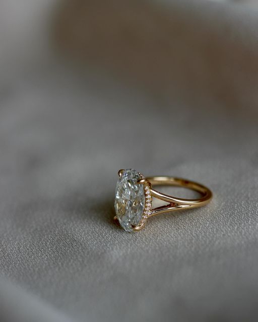 a diamond ring sitting on top of a white cloth