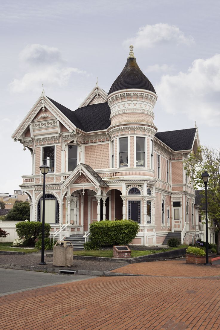 a large pink house with a black roof and white trim on it's side