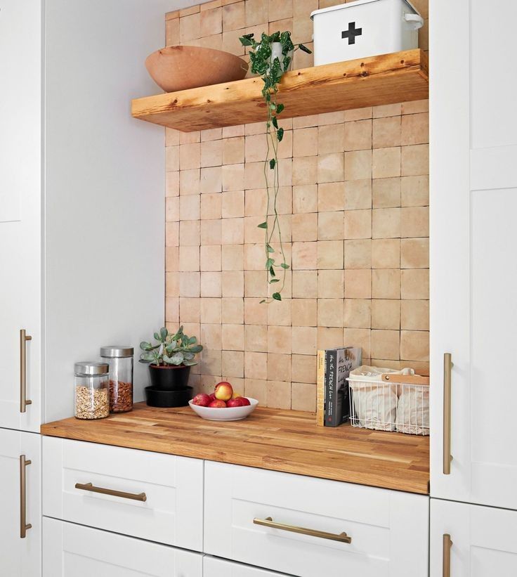 a kitchen with white cabinets and wooden shelves