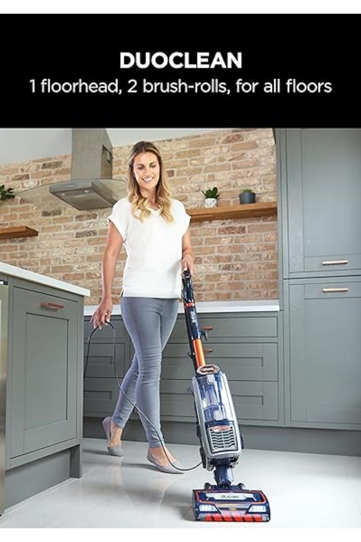 a woman is cleaning the floor with a vacuum