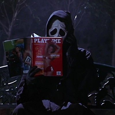 a person wearing a mask and holding a book in front of their face while sitting on a bench