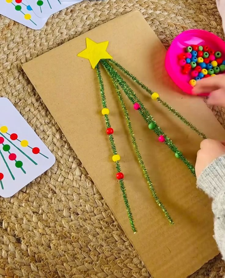 a child is making a christmas tree out of beads and straws on the floor